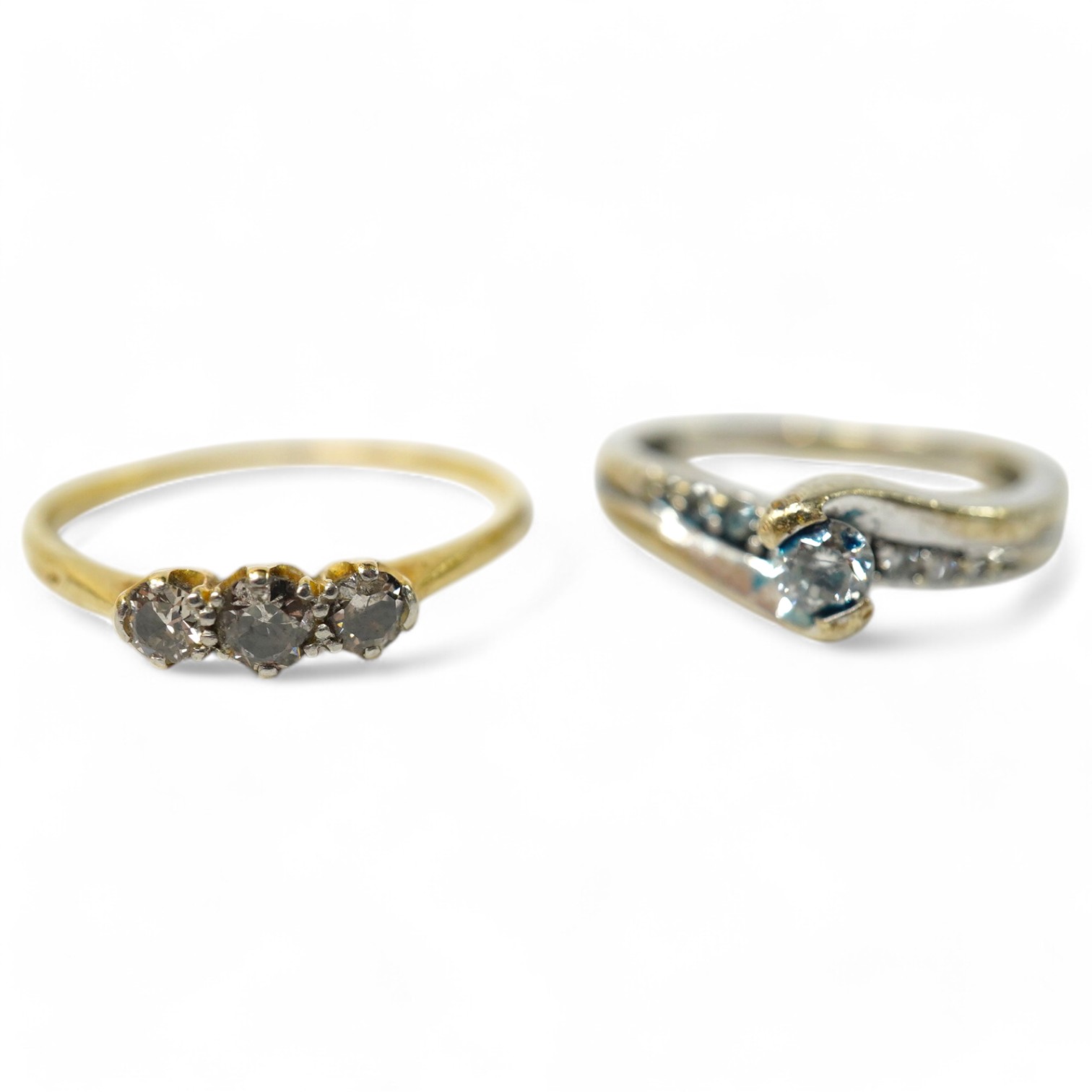 A small yellow metal and three stone diamond set ring, size R/S and a modern 9kt and single stone diamond ring, with diamond chip set shoulders, gross weight 4.3 grams.